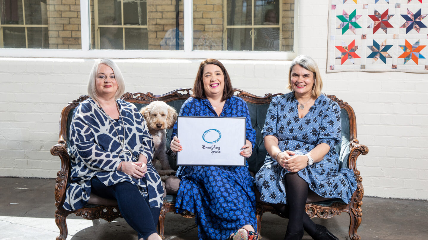 Three women and a dog sitting on sofa
