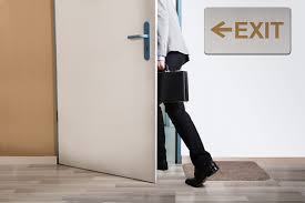 a person walking out of door marked exit