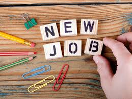 Blocks of letters spelling out New Job with stationary surrounding on a wooden table