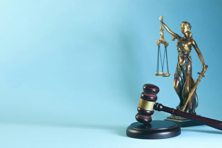 judges hammer and statue of a female blindfolded holding scales of justice